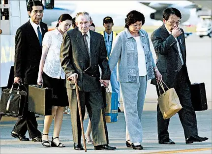  ?? KOICHI KAMOSHIDA/GETTY 2004 ?? Charles Jenkins walks upon his arrival in Tokyo with wife Hitomi Soga after his 2004 release by North Korea. Jenkins and Soga met in North Korea.