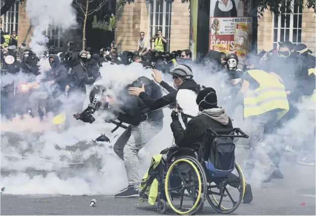  ??  ?? 0 French police clash with protesters as tens of thousands of people took to the streets of Paris yesterday for May Day rallies in a city gripped by tight security