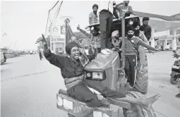  ?? MANISH SWARUP/AP ?? Farmers hail news of the repeal of farm laws pushed by the prime minister that they were protesting against, in Singhu, on the outskirts of New Delhi, India, Friday.