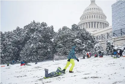  ?? Al drago/afp ?? Un hombre lleva a su hijo en un trineo frente al Capitolio de Washington