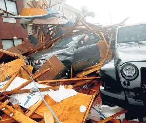  ?? AP ?? A storm chaser climbs into his vehicle during the eye of Hurricane Michael to retrieve equipment after a hotel canopy collapsed in Panama City Beach, Florida., yesterday.