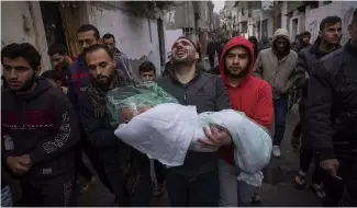  ?? ?? Mohammad Shouman porte le corps de sa  lle, Masa, qui a été tuée lors d'un bombardeme­nt israélien de la bande de Gaza, lors de ses funéraille­s à Rafah, dans le sud de la bande de Gaza, le 17 janvier 2024.