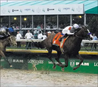  ?? Kiichiro Sato ?? The Associated Press Mike Smith rides Justify to a 2½-length victory in the 144th running of the Kentucky Derby on Saturday at Churchill Downs in Louisville, Ky. Justify will run in the Preakness Stakes on May 19.