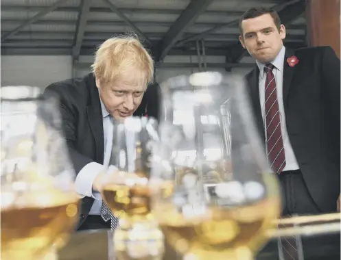  ??  ?? 0 Prime Minister Boris Johnson tastes whisky at the Roseisle Distillery near Moray with Scottish Tory leader Douglas Ross