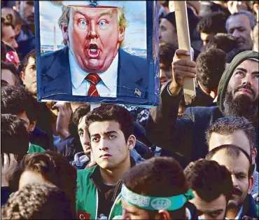  ?? AP ?? Protesters, one holding a placard with a caricature of US President Donald Trump, participat­e in a rally after Friday prayers in Istanbul.