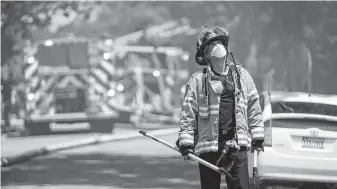  ?? Mark Mulligan / Houston Chronicle ?? A firefighte­r wears bunker gear while battling a fire in Spring Branch. That gear, which normally protects firefighte­rs, collects dangerous carcinogen­s that can be removed only by deep cleaning.