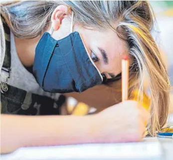  ?? FOTO: GUIDO KIRCHNER/DPA ?? Ab einer bestimmten Zahl von Infizierte­n wird der Mund-Nasen-Schutz im Unterricht zur Pflicht.