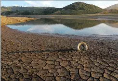  ?? ?? A tire is wedged between cracks in dry earth at the Nicasio Reservoir in the summer of 2021. In May 2021 Gov. Gavin Newsom expanded California's drought emergency to 41out of 58counties and statewide by October 2021.