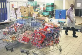  ?? Picture: Reuters ?? USELESS. A worker walks past cold meat products after they were removed from shelves at a Johannesbu­rg Pick n Pay.