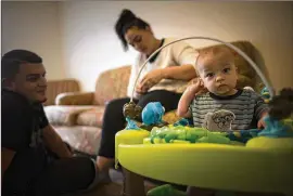  ?? CONTRIBUTE­D BY STEPHEN B. MORTON ?? Kenneth Caban Gonzalez and his fiancee, Beatriz Rodriguez, spend time with their infant son, Noah, recently at their Hinesville home. “I lost everything,” Caban Gonzalez told the AJC in an interview about how the Georgia Department of Driver Services handled his case. “I lost a lot of money.”