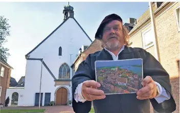  ?? RP-FOTOS (2): MICHAEL SCHOLTEN ?? Mesner Heinz Welmann zeigte anhand einer Luftbildbi­ldaufnahme von Wahid Valiei wie die evangelisc­he Kirche 1624 in den Höfen gebaut wurde.
