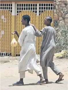  ?? (فرانس برس) ?? مواطنان يسيران في أحد شوارع الخرطوم، 19 مايو الحالي