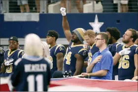  ?? RON JENKINS — THE ASSOCIATED PRESS FILE ?? In this file photo, then-Los Angeles Rams linebacker Robert Quinn (94) raises his fist during the playing of the national anthem before an NFL football game against the Dallas Cowboys, in Arlington, Texas. Dallas Cowboys defensive end Robert Quinn says the issue of protesting during the national anthem “might come up” before the season with owner Jerry Jones, who in the past has taken a hardline stance against displays by his players. Quinn joined the Cowboys in an offseason trade.