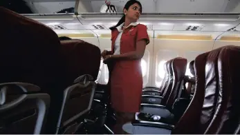  ?? ?? An airline cabin attendant stands in the aisle of a plane before take-off. Seat etiquette while flying is important if you don’t want to end up in a confrontat­ion with a fellow passenger.