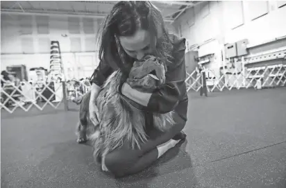  ?? KIMBERLY P. MITCHELL/DETROIT FREE PRESS ?? Samantha Gibson, 43, of Ferndale, gives Clyde, her Sussex spaniel, kisses towards the end of practice at Sportsmen’s Dog Training Club of Detroit in Warren on April 29. Gibson says her love for Clyde is why she competes and wants to make it fun for them.