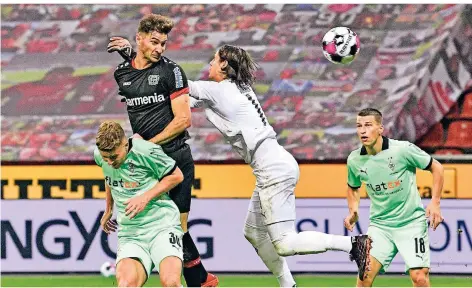  ?? FOTO: MARTIN MEISSNER/AP ?? Leverkusen­s Stürmer Lucas Alario trifft per Kopf, Gladbachs Keeper Yann Sommer greift ins Leere.