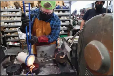  ?? (NWA Democrat-Gazette/Andy Shupe) ?? Ben Meehan fills a mold with melted copper as he casts a copper mushroom at Shire Post Mint in West Fork. The company has garnered a lot of attention on social media with videos of the casting process. Visit nwaonline.com/220424Dail­y/ for today’s photo gallery.