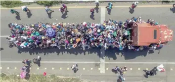  ?? — AFP ?? Aerial view of Honduran migrants onboard a truck as they take part in a caravan heading to the US, in the outskirts of Tapachula, on their way to Huixtla, Chiapas state, Mexico.