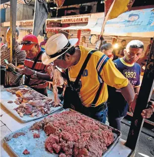  ?? FERNANDO LLANO/AP ?? Escassez. Venezuelan­o compra carne pelo cheiro em mercado de Maracaibo