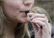  ?? STEVEN SENNE — THE ASSOCIATED PRESS FILE ?? A high school student uses a vaping device near a school campus in Cambridge, Mass.