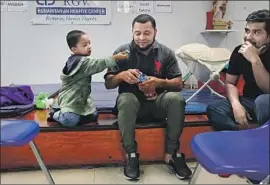  ?? Spencer Platt Getty Images ?? A FATHER and son from Honduras relax at the Catholic Charities Humanitari­an Respite Center in McAllen, Texas, after recently crossing the U.S.-Mexico border.