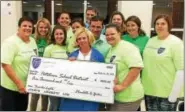  ?? EVAN BRANDT — DIGITAL FIRST MEDIA ?? Pottstown School Board member Polly Weand, in the middle, accepts a $5,000 donation from the Federation of Pottstown Teachers for the campaign to replace the lights at Grigg Memorial Stadium.