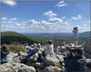  ?? COURTESY OF HAWK MOUNTAIN SANCTUARY ?? Counters and visitors scan the skies for migrating raptors from Hawk Mountain’s North Lookout.