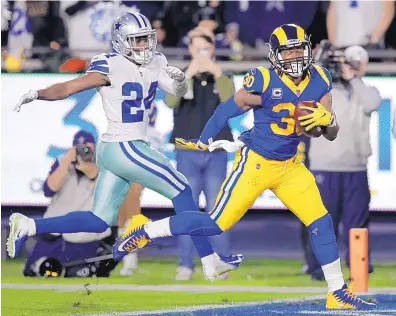  ?? JAE C. HONG/ASSOCIATED PRESS ?? Rams running back Todd Gurley, right, scores past Dallas cornerback Chidobe Awuzie during the first half of LA’s divisionro­und win over visiting Dallas on Saturday night.