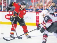  ?? USA TODAY SPORTS ?? The Flames’ Mark Giordano, left, passes the puck against the Coyotes.