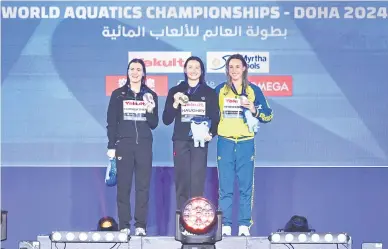  ?? — Gambar AFP ?? KENANGAN MANIS: (Dari kiri) Pemenang pingat perak, Erika Fairweathe­r, dari New Zealand, Haughey dari Hong Kong memenangi pingat emas bersama pemenang pingat gangsa, Brianna Throssell dari Australia bergambar di atas podium semasa sesi penyampaia­n pingat pada Kejohanan Akuatik Dunia 2024 di Aspire Dome di Doha.