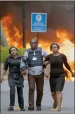  ?? The Associated Press ?? Security forces help civilians flee the scene as cars burn behind at a hotel complex in Nairobi, Kenya, Tuesday.
