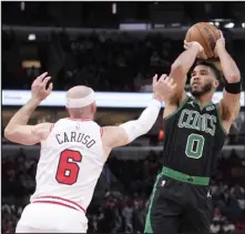  ?? CHARLES REX ARBOGAST — THE ASSOCIATED PRESS ?? Boston Celtics’ Jayson Tatum shoots over Chicago Bulls’ Alex Caruso during the first half Saturday in Chicago.