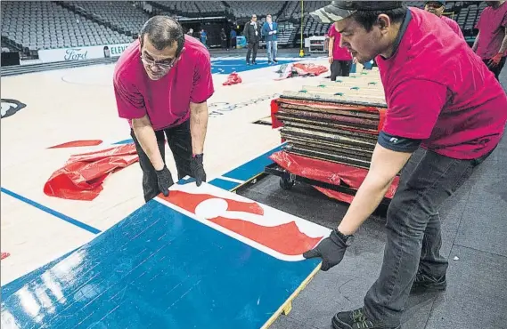  ?? FOTO: AP ?? Operarios del American Airlines de Dallas desmontan el piso tras el último partido.
El retorno de la NBA a la acción todavía resulta incierto dos semanas después