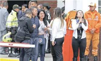  ??  ?? FAMILY members of victims of a bombing gather outside the entrance to the General Santander police academy in Bogota, Colombia, on Thursday. | AP African News Agency (ANA)