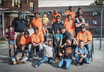  ?? THE WASHINGTON POST ?? Sandtown children with Deontray Burgess, top right, 22, who is not an ex-felon and was hired by Safe Streets to help with youth outreach, former felons and Safe Streets interrupte­rs. First row, from left: Julian ‘JJ’ Allen, Imhotep Fatiu, Greg...