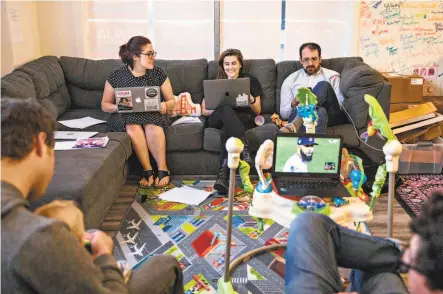  ?? Photos by Jessica Christian / The Chronicle ?? YIMBY Action Executive Director Laura Clark (left) chats with the organizati­on’s Laura Fingal-Surma and Theo Gordon as they work on their computers during a YIMBY Action Leads meeting at the group’s headquarte­rs in San Francisco.