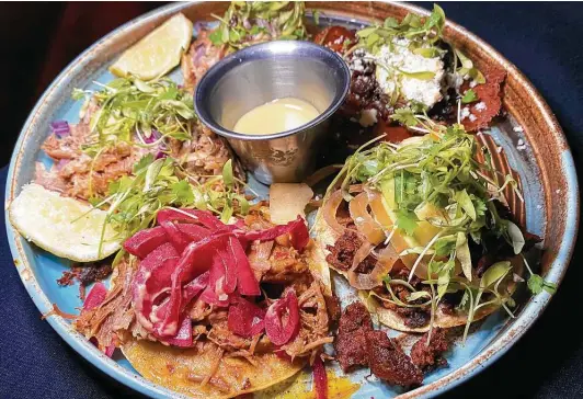  ?? Mike Sutter / Staff ?? A “taco tasting menu” of cochinita pibil, clockwise from front, carnitas, beef suadero, beef rib-eye and pork al pastor is ambitious, showy, overpriced and bad.