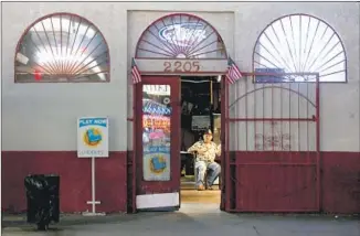  ??  ?? THE MILE-LONG strip of North Broadway that runs through Lincoln Heights is still mostly lined with old bars like the Broadway Social Center, above, bargain stores and fast-food restaurant­s.