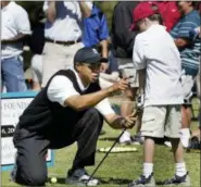  ?? CHUCK BURTON — THE ASSOCIATED PRESS FILE ?? Tiger Woods helps Damon Eames, 8, with his swing during a golf clinic at Stryker Golf Course at Fort Bragg, N.C. Michael Jordan and other iconic athletes of the 1980s and 90s establishe­d the power of individual sports brands, a transition­al platform,...