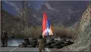  ?? (AP/Sergei Grits) ?? An ethnic Armenian soldier walks with Nagorno-Karabakh’s flag toward a checkpoint Wednesday near the village of Charektar in the separatist region.