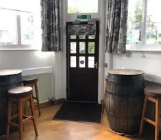  ?? ?? This is the front door viewed from the main bar. The large barrel tables were placed on carpet circles so they can be easily re-positioned on the smooth wooden floor
