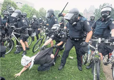  ?? DARREN CALABRESE THE CANADIAN PRESS FILE PHOTO ?? Police club an activist during the G20 Summit in Toronto in 2010. Most officers learn to like the “things” in policing, such as the look of the police cars, the uniforms, the latest guns, David Cassels writes. The image begins to dominate their thinking.