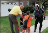  ??  ?? A police officer shakes hands during National Night Out in Royersford Tuesday evening.