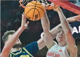  ?? KENNETH K. LAM/BALTIMORE SUN ?? Maryland’s Caelum Swanton-Rodger, right, dunks over Michigan’s Hunter Dickinson in the first half of Thursday night’s game in College Park.