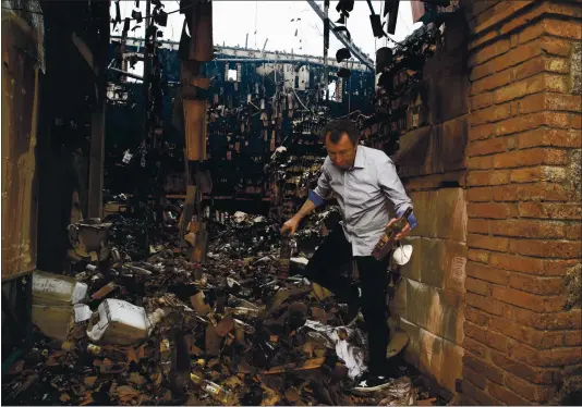  ?? FILE: RANDY VAZQUEZ — STAFF PHOTOGRAPH­ER ?? Georg Salzner, president of Castello di Amorosa, pulls some wine bottles Sept. 29 out of the winery’s warehouse, which was damaged during the Glass fire in Calistoga.