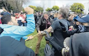  ?? Dan Honda East Bay Times ?? COUNTER-PROTESTERS try to wrest a wooden pole away from a member of a pro-Trump rally Saturday in Berkeley. Police confiscate­d metal pipes, bats, two-by-fours and bricks. At least 10 people were arrested.