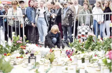  ??  ?? Candles and flowers are left at the makeshift memorial by well wishers for the victims of Friday’s stabbings at the Turku Market Square, Finland. — AFP photo