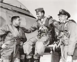  ??  ?? Pilots sharing a laugh after their overflight: (left to right) LaVerne Griffin, Maj. George Saylor (on wing), and Lt. Pete Garrison. (Photo courtesy of James P. Busha)