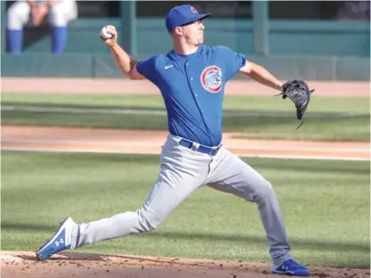  ?? KAMIL KRZACZYNSK­I/AP ?? Tyler Chatwood (top) and Alec Mills went head-to-head during an intrasquad scrimmage Sunday at Wrigley Field.