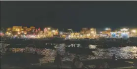  ?? (AP Photo/Rajesh Kumar Singh) ?? Tourists sit on a boat and watch Hindu priests perform evening rituals on the banks of the River Ganges in Varanasi, India, on March 14. Varanasi is among the world’s oldest cities, and millions of Hindu pilgrims gather annually here for ritual bathing and prayers in the Ganges River, considered holiest by Hindus.